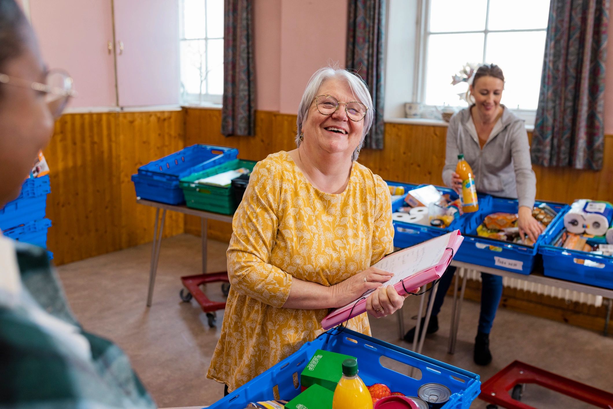 Community food bank volunteer smiling while organizing supplies