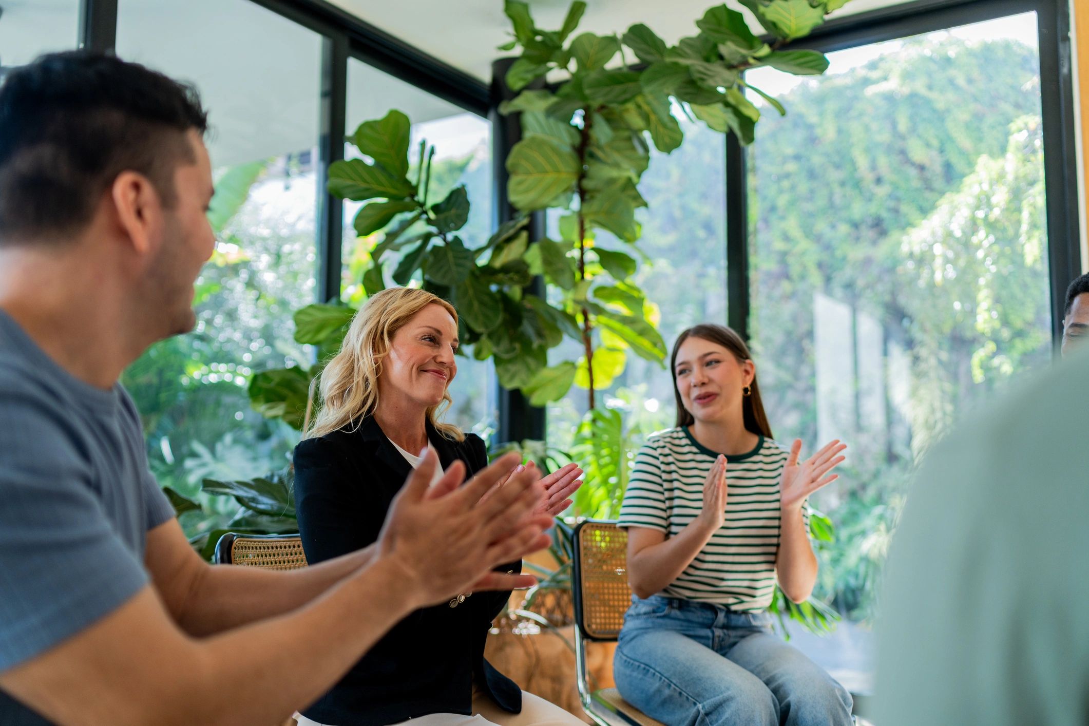 People talking and applauding in a supportive group setting